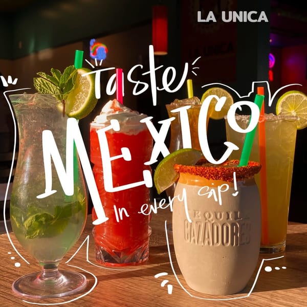 Assortment of colorful Mexican drinks, including margaritas and a mojito, on a wooden table.