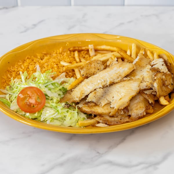 La Unica's fried fish platter with rice, french fries, shredded lettuce, and a tomato slice.