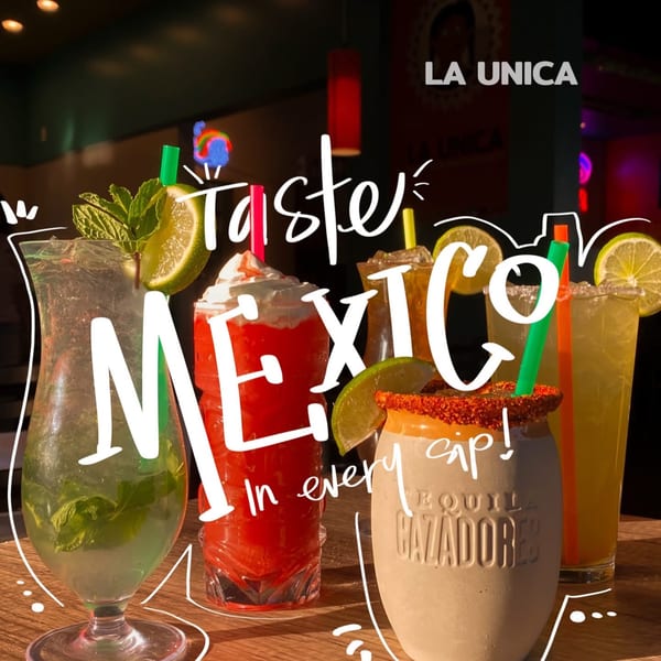 Assortment of colorful Mexican drinks, including margaritas and a mojito, on a wooden table at La Unica.