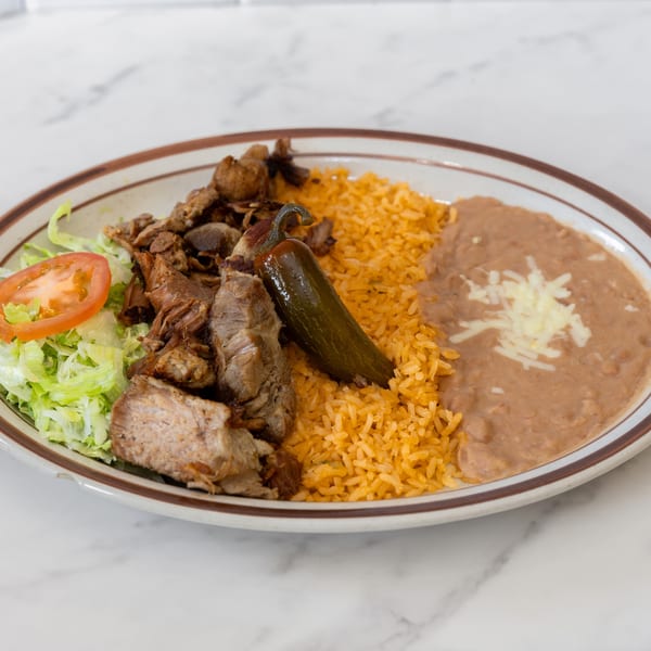 La Unica Mexican Restaurant's carne asada plate with rice, refried beans, lettuce, tomato, and a jalapeño.