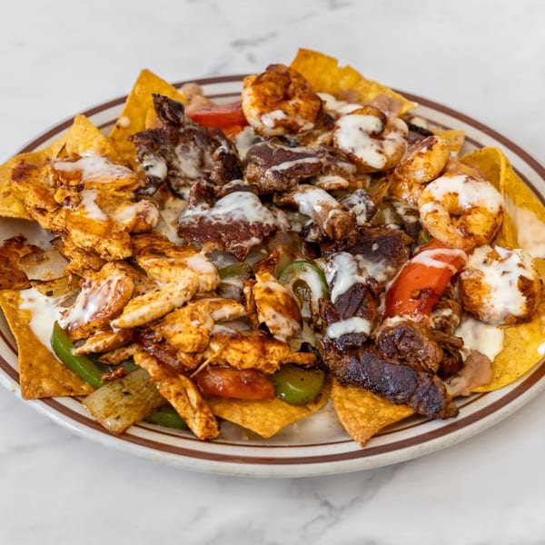 La Unica Mexican Restaurant's nachos with steak, chicken, shrimp, peppers, and onions, drizzled with white sauce.