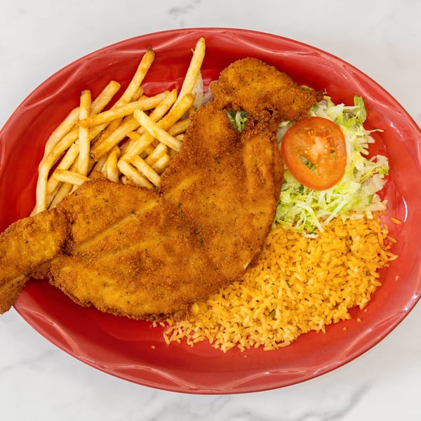 La Unica Mexican Restaurant's breaded fish fillet with french fries, rice, shredded lettuce, and a tomato slice.