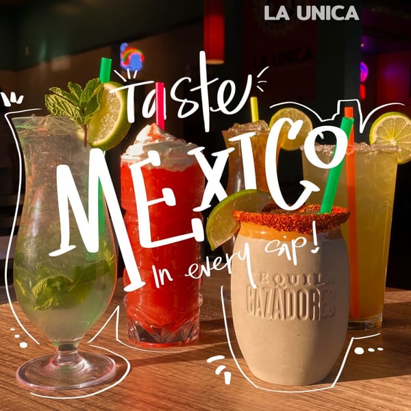 Assortment of colorful Mexican cocktails, including mojitos and margaritas, on a wooden table at La Unica.